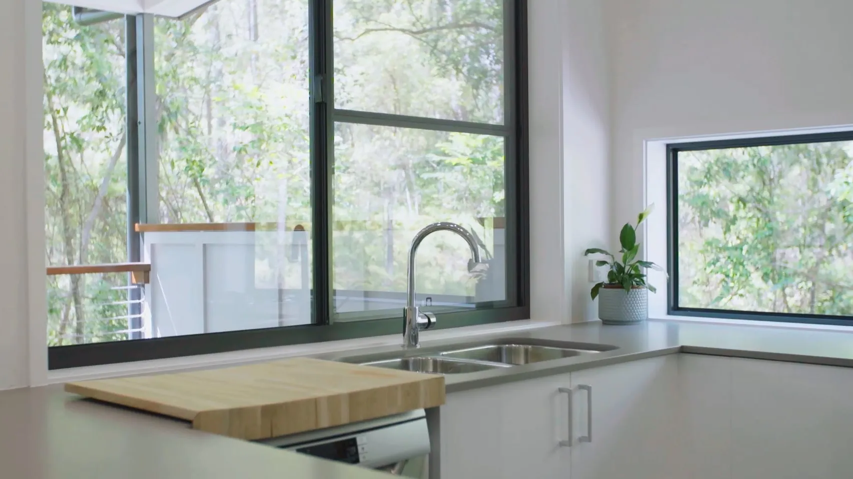 Granny Flat Kitchen Designed for Independent Living Self-contained granny flat kitchen with large windows overlooking greenery